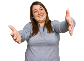 Beautiful brunette plus size woman wearing casual clothes looking at the camera smiling with open arms for hug. cheerful expression embracing happiness.