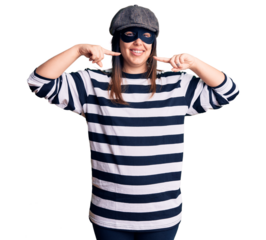 Young beautiful brunette woman wearing burglar mask smiling cheerful showing and pointing with fingers teeth and mouth. dental health concept.