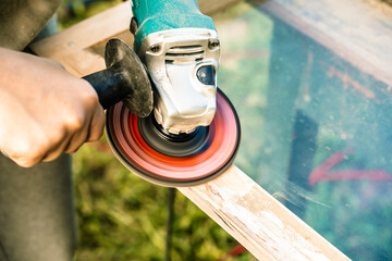 Wood sanding, furniture restoration and restoration. A carpenter sands an old window in his...