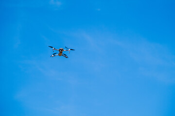 drone flying against a clear blue sky, symbolizing modern technology and surveillance.