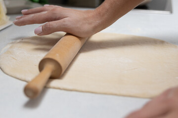 Girl rolling out dough in the kitchen