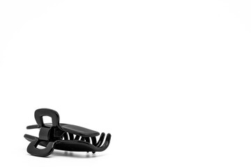 Black plastic hairclip or hairpin isolated on white background with copy space. Hair accessories.