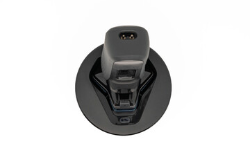 Electric shave machine for men on the cleaning pod or cleaning station, isolated on white with copy space. Electric shaver. Top view or flat lay, close-up.