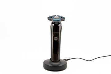 Electric shave machine for men on the charging station, isolated on white with copy space. Electric shaver.