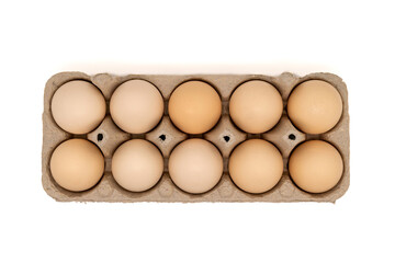 Cardboard egg box with ten chicken eggs isolated on white background with copy space. Top view or flat lay.