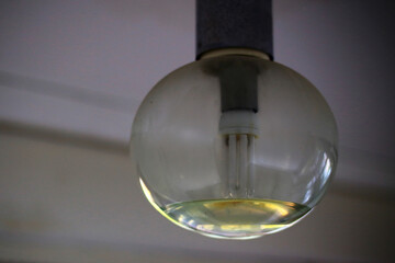 Glass bowl of a ceiling lamp partially filled due to water damage