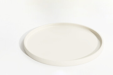 Modern round beige plate shape podium on white table counter in sunlight for luxury organic cosmetic, skincare, beauty, body, hair care, food, drink product display background 3D
