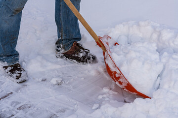 Man cleaning snow with shovel in winter day, close up