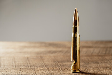 Bottle opener made from brass bullet on wooden table, closeup, copy space