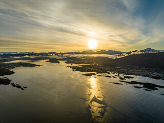 aerial view over norwegian landscape with islands and mountains during sunrise