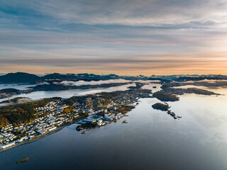 scenic aerial view over city of Alesund in the morning during sunrise with a big cruise ship in port