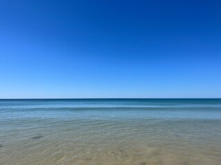 Fototapeta na wymiar Calm blue ocean horizon, clear blue sky, sea surface background