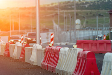 Red, white plastic safety barriers along road. Ensuring road safety with visible barriers. Effective safety measures for roadside work.
