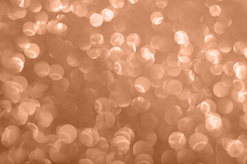 Abstract peach background with bokeh effect. Blurred glitter.
