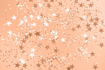 Peach Christmas background with confetti.