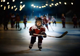 Fotobehang Little boy ice hockey player with hockey stick on large arena during training.Macro.AI Generative. © DenisMArt