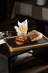 fresh tasty burger and french fries on wooden desk