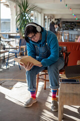Portrait of a happy smiling neutral gender teenager surrounded with indoor plants
