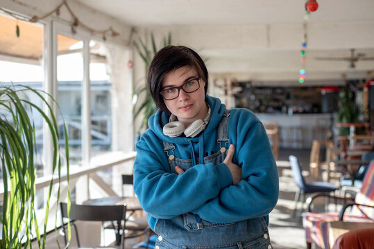 Portrait of a confident happy smiling transgender teenager standing near the window - Powered by Adobe