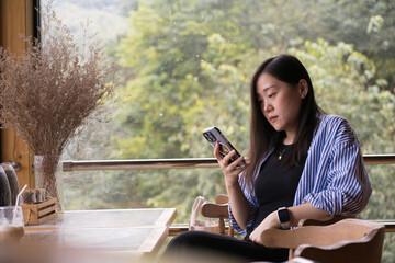 digital nomad concept asian freelancer woman use smart phone to work at mountain view of coffeeshop