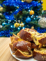 slices of traditional home made sweets cozoac or sweet bread with christmas tree in the background