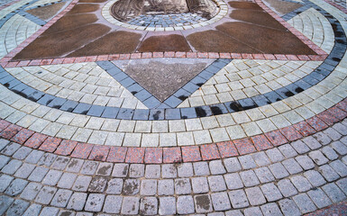 The pavement is made of cobblestones of different colors.
