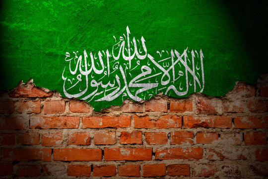 A wall with a painting of the hamas flag at night.