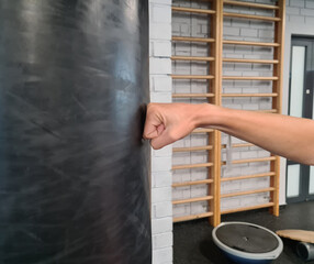 Hit punching bag in gym and woman hand fist hits punching bag