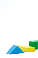 Colorful wooden blocks cuboid and triangle, in green, yellow and blue isolated on a white...