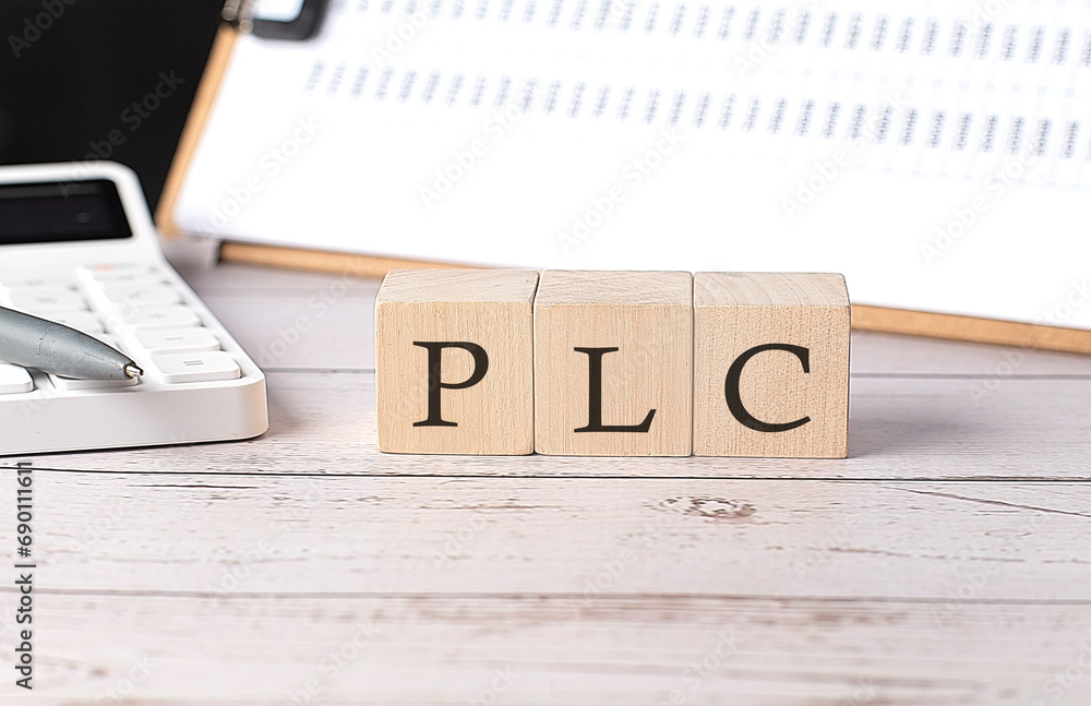 Poster plc word on a wooden block with clipboard and calcuator