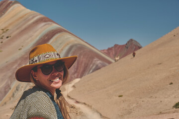Panoramic view, Young girl in front of the Vinicunca Rainbow Mountain, Peru South America