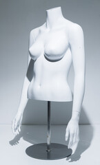 Naklejka premium A Female Mannequin Torso With adjustable arms Arms, gloss White Chest . Bust Display on metal pole and base. Fashion model for retail stores to show off clothing. Retail displays.