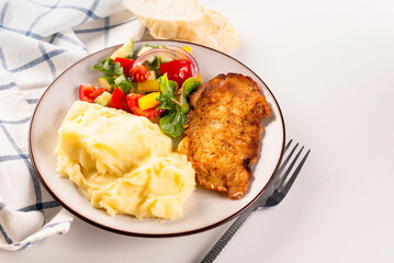 Fried chicken steak or schnitzel with mashed potatoes and vegetables salad in plate