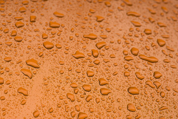 Fototapeta na wymiar orange water drops on metal surface perspective soft focus concept wallpaper background mockup paint in peach fuzz trendy color