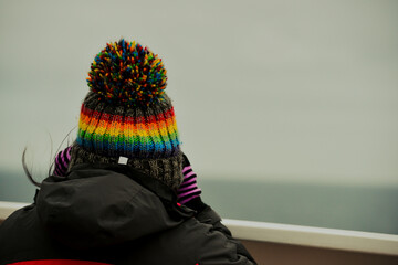 Close up of a woman with Binoculars looking out into the distance in the winter with a woolly hat...