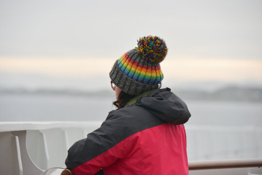 Woman looking out in the winter wearing a woolly hat and coat.