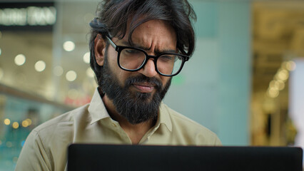 Stressed upset Indian Muslim bearded man in glasses talk video call has problem with laptop...