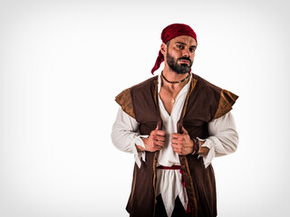 A muscular topless man with a red bandanna and pirate costume, standing isolated in front of a...