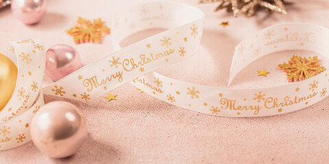 Festive Christmas and New Year background with gold and pink baubles, ribbons and stars. White...