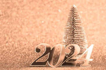 Color of the year 2024 peach fuzz new year background decorative tree and inscription, selective focus