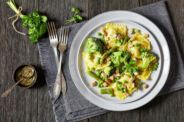 ravioli primavera with ham on a grey plate