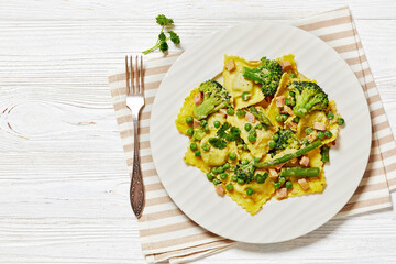 ravioli primavera with ham on a white plate