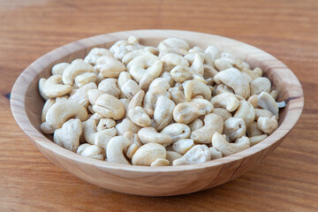 Cashews in a wooden bowl. Nuts are healthy food. Wooden background. Cashew kernel