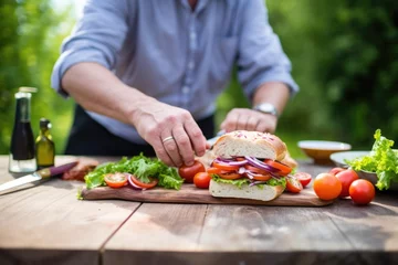 Fotobehang man rustic sandwich loaf on picnic table for a meal © primopiano