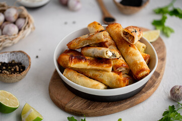 Turkish Cigara Börek (Sigara böreği) or Cigarette Pastry with Spinach and Feta Cheese with yogurt dip. Finger food. Spring rolls. Top view