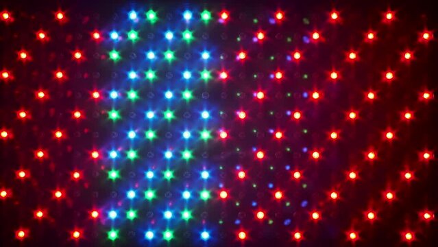 Multi-colored background of glowing RGB LEDs light with different effects. LED Panel with many luminous semiconductor diodes, close-up. LED-dots background of red, green and blue light-emitting diodes