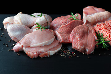 Different types of raw meat - beef, pork, lamb, chicken on a wooden board