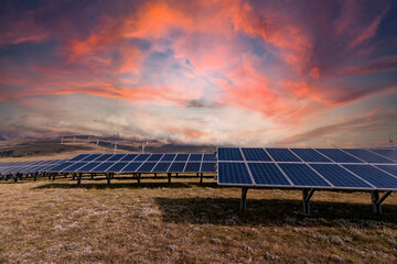 Mountain landscape in winter with snow and a photovoltaic system at sunset. Solar panels for the...