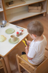 little child playing with kitchen toys