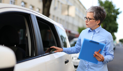 Businesswoman agent inspect document in car, providing insurance assistance, ensuring safety.